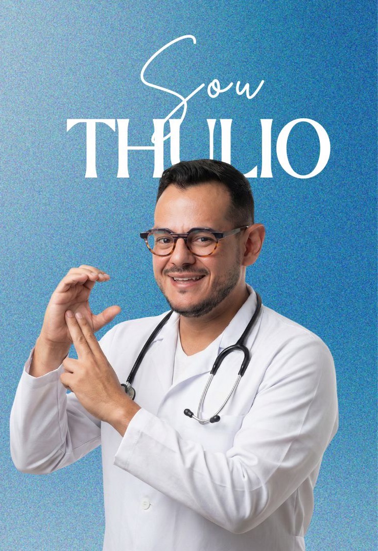 Dr. Thulio Moutinho de jaleco e estetoscópio, sinalizando em Libras